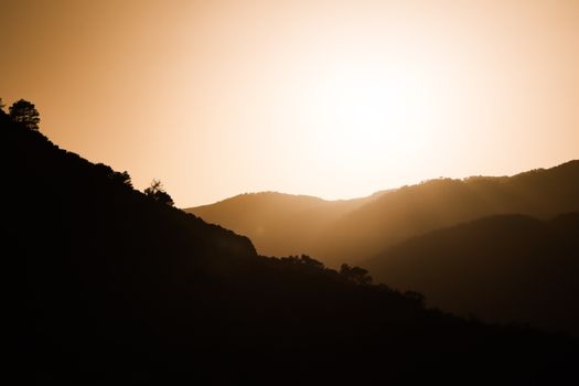 A stunning sunset casting silhouettes over the Cheraia mountains in Skikda Province, Algeria.