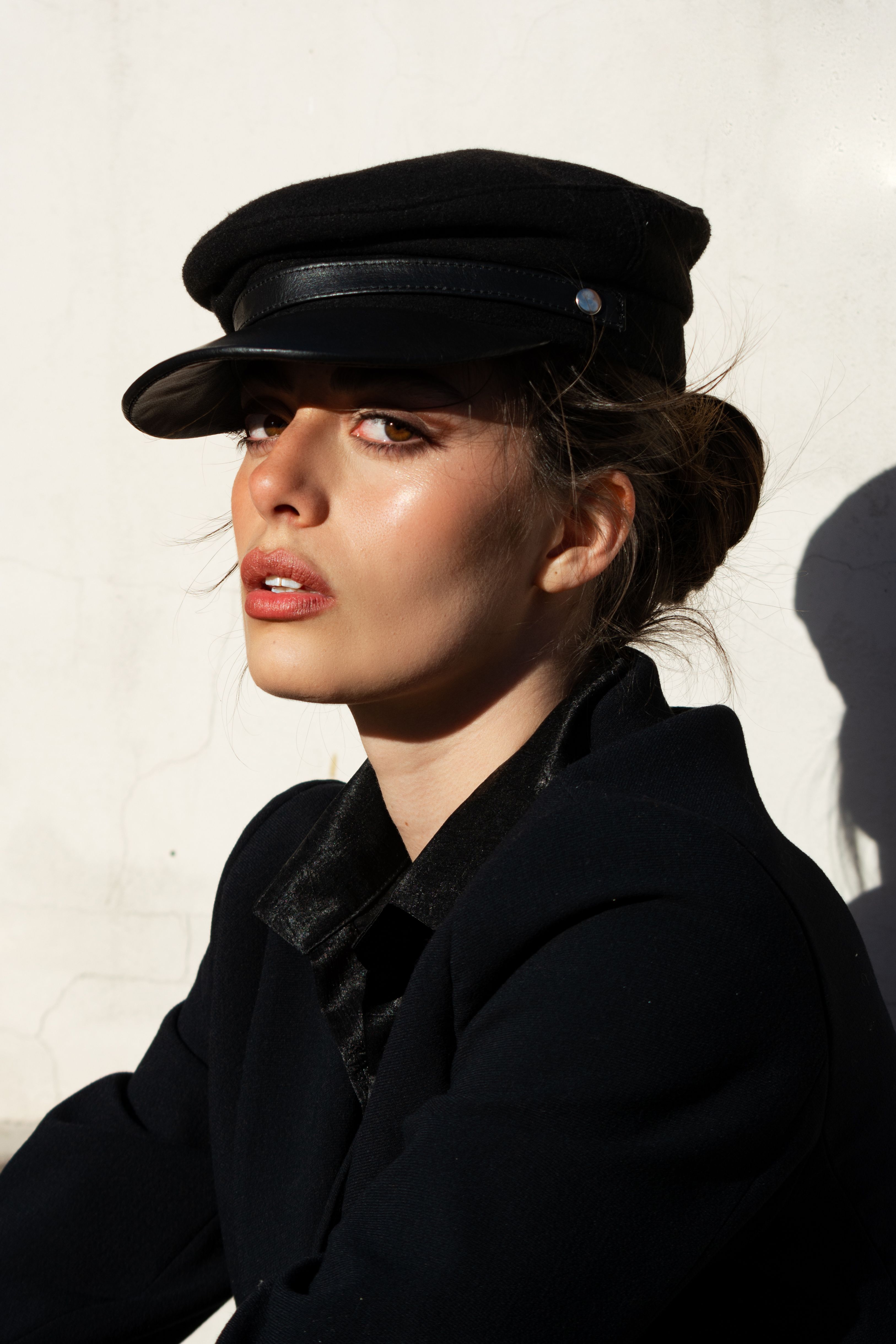 Stylish portrait of a young woman in Córdoba, Argentina wearing a black hat.