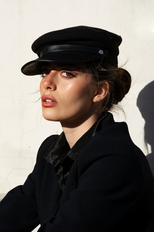A Woman in Black Coat and Black Cap
