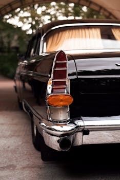 Rear view of a vintage black car outdoors with elegant design.