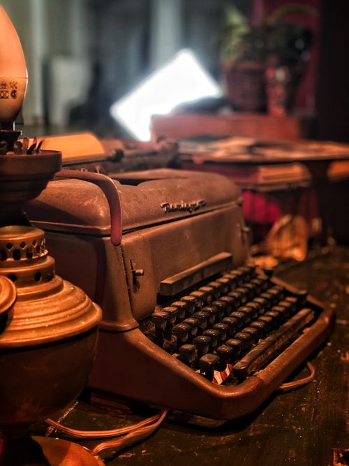 Free Vintage typewriter on rustic desk with warm lighting creating a nostalgic atmosphere. Stock Photo