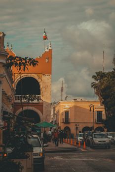 Charming view of Mérida's streets with colonial buildings under dramatic clouds.