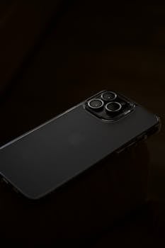 A close-up shot of a modern smartphone with triple cameras on a dark background.