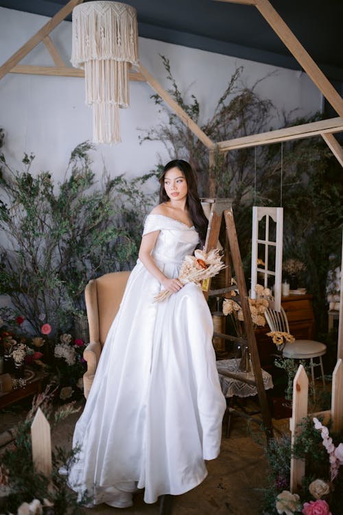 Woman in White Dress Leaning on Brown Wooden Ladder