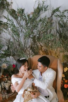 Delightful wedding moment with bride laughing and groom tenderly touching in a cozy setting.