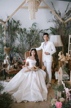 Beautiful indoor wedding portrait featuring an Asian couple in a romantic setting.