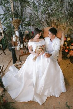 A loving couple in a wedding attire during a romantic indoor photoshoot.