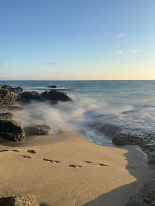 Free Tranquil waves and golden sand at Laguna Beach, CA capture a peaceful ocean sunset. Stock Photo