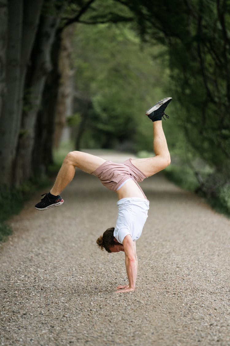 Man In Yoga Position On Alley In Park