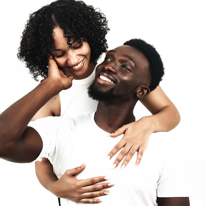 Two people laughing in a close embrace against a bright backdrop — photo by Kai Blac on Pexels