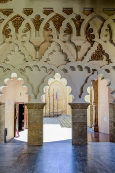 Explore the intricate arches and columns of Aljafería Palace's stunning interior in Zaragoza, Spain.