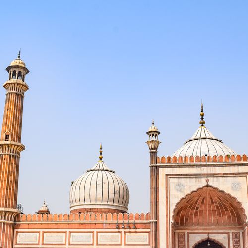 Free Elegant architectural capture of Jama Masjid's domes and minaret against a clear sky. Stock Photo