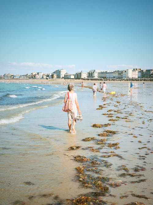 People Walking on the Beach under the Blue Sky