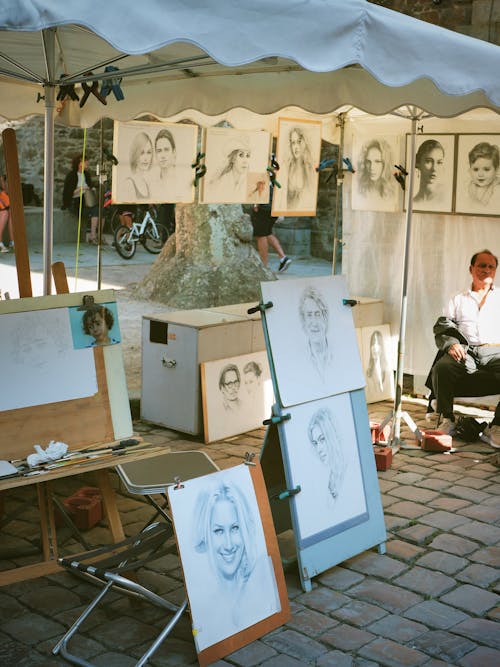 Man Drawing and Selling Portraits on the Street 