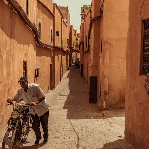 Man with a Motorbike in a Narrow Alley 