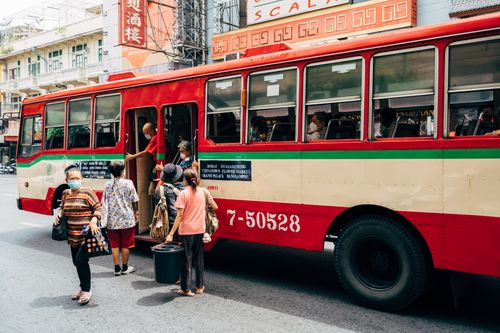Free Vibrant city scene with people boarding a bus in bustling Bangkok, Thailand. Stock Photo