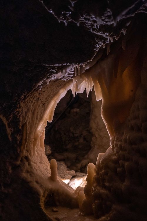 Free Explore a mysterious cave illuminated by natural formations of stalactites and stalagmites. Stock Photo