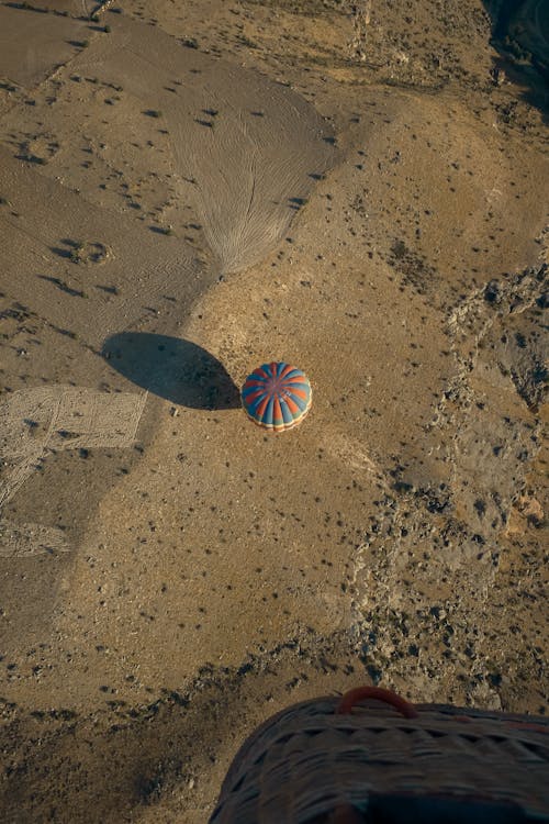 Aerial View of a Blue and Red Hot Air Balloon on Brown Sand