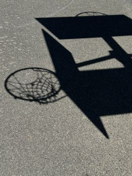 Creative shadow of a basketball hoop cast on an outdoor court