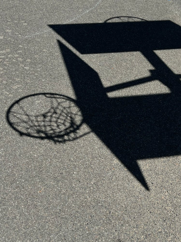 Shadow Of A Basketball Hoop On The Ground 