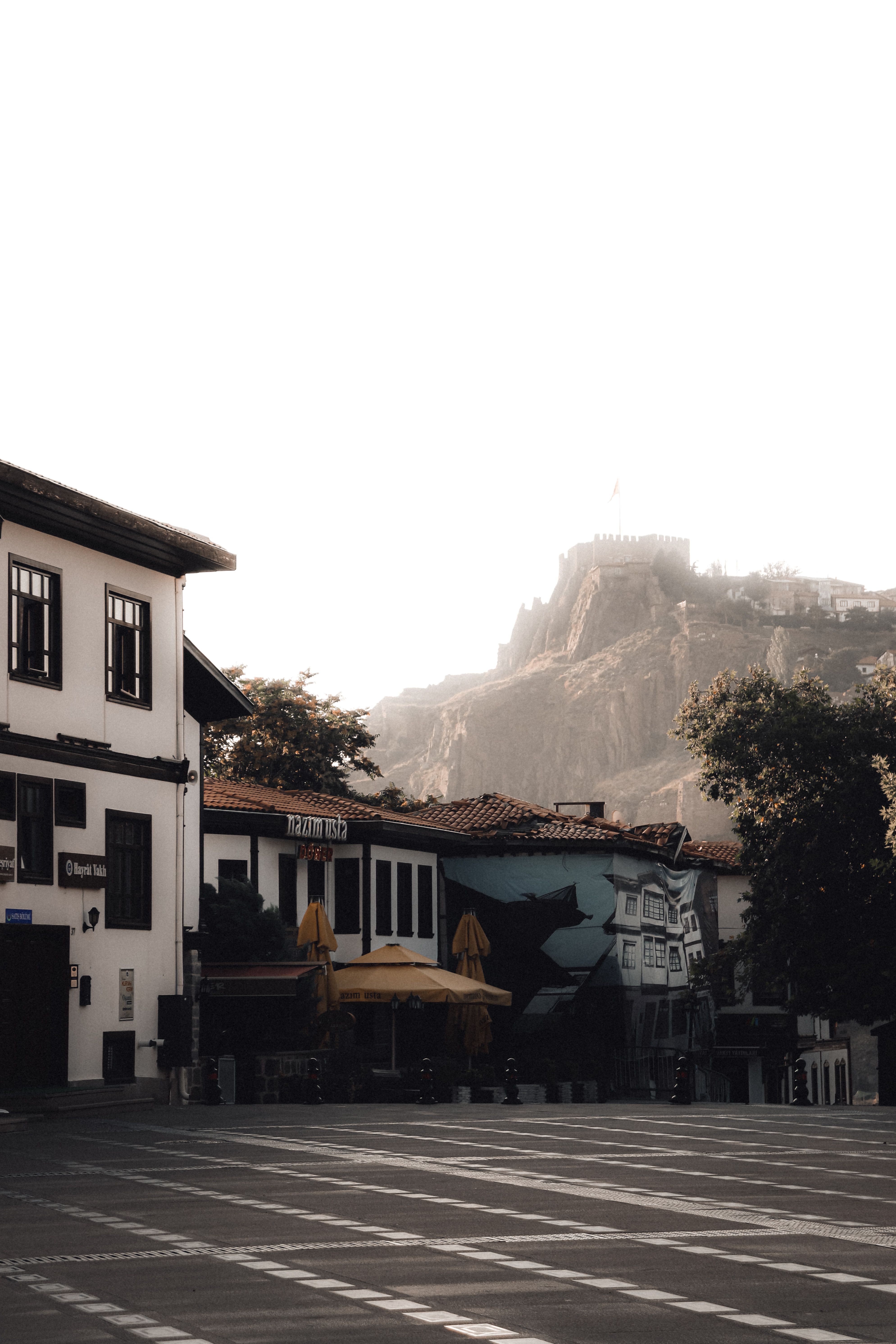 Charming street in Ankara, Turkey with a view of a historic castle in the distance.