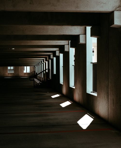 Free Explore the striking design of a concrete corridor with dramatic light and shadows. Stock Photo