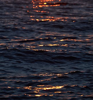 Golden sunset reflections on ocean waves in Parga, Greece, creating a tranquil scene.