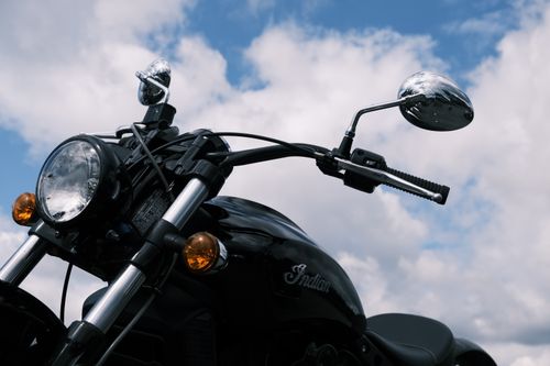 Free Close-up view of a classic motorcycle with chrome details and cloudy sky backdrop. Stock Photo