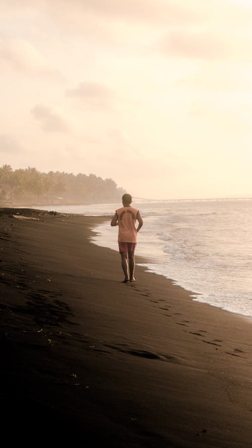 Backview of Person jogging on Beach Sand 