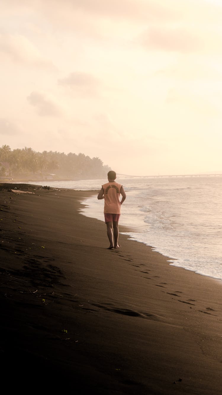 Backview Of Person Jogging On Beach Sand 