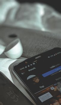 Close-up of smartphone with social media app open, next to a wireless earbud on a fabric surface.