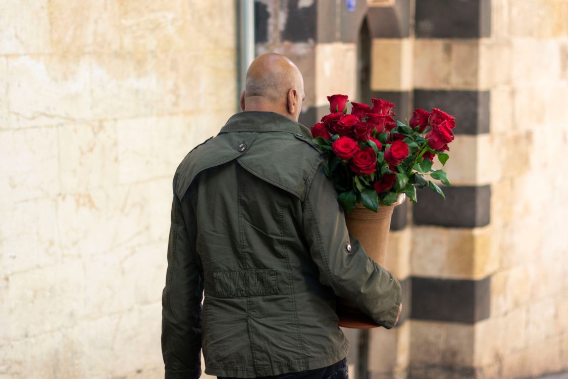 Man Carrying Roses Backview of Man carrying Red Roses · Free Stock Photo