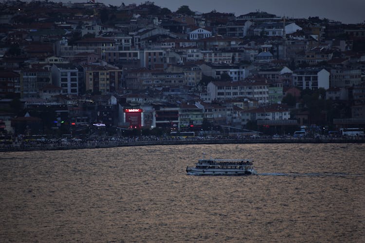 Ferry Boat On A River Near City 