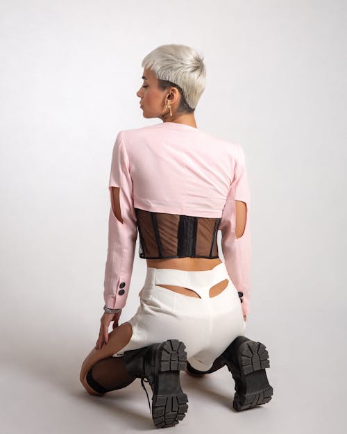 Free A Woman Wearing a Pink Top and a White Skirt Kneeling Stock Photo