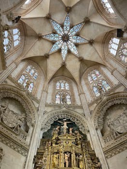 Stunning view of a Gothic cathedral's intricate ceiling and architecture, highlighting stained glass windows.