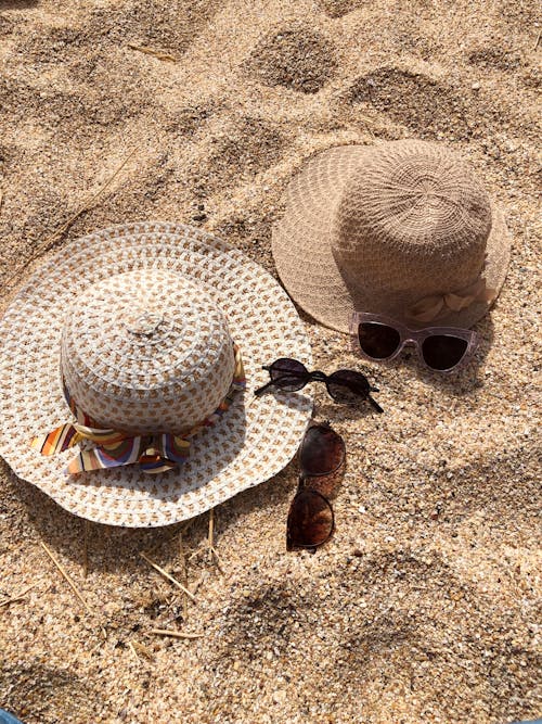 Photo of Sunglasses and Hats on Sand