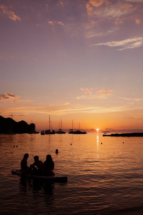 Silhouettes of People on Boat during Sunset