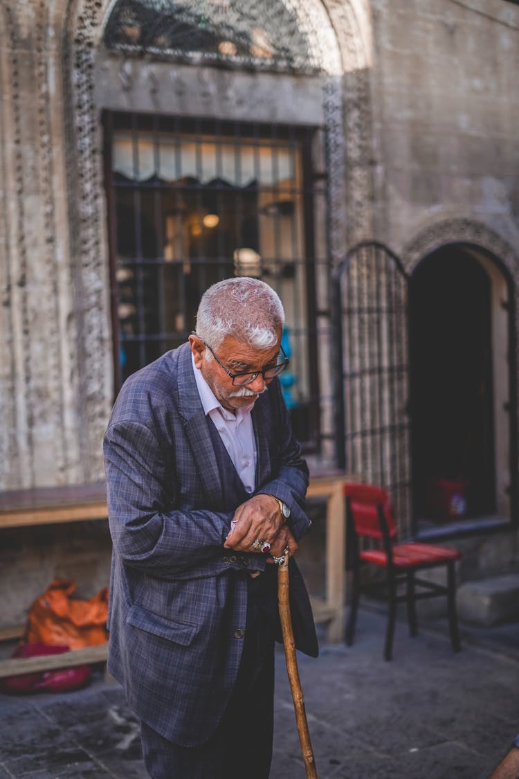 Elderly Man Using A Wooden Cane 