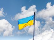 Vibrant Ukrainian flag waving against a bright, cloudy sky.