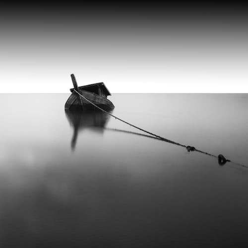 Graustufenfotografie Des Bootes Auf Ruhigem Wasser