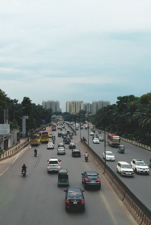 Free Busy street in Dhaka, Bangladesh, with diverse vehicles under a cloudy sky. Stock Photo