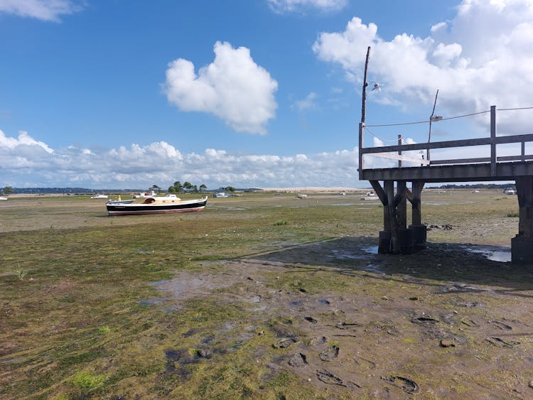 Brown Wooden Dock And A Yacht In A Dry Lake 