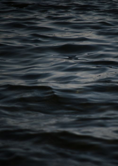 Free A close-up view of dark water ripples, capturing a moody and tranquil atmosphere. Stock Photo