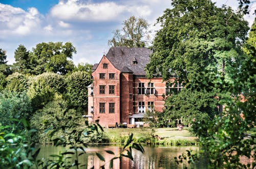 Concrete Building with Red Brick Walls Near Green Trees