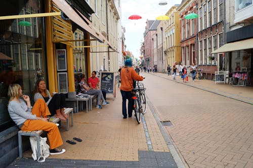 免费 拿着自行车的人站立在大厦旁边 素材图片