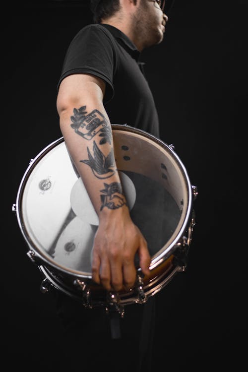 Man in Black T-shirt Holding a Drum