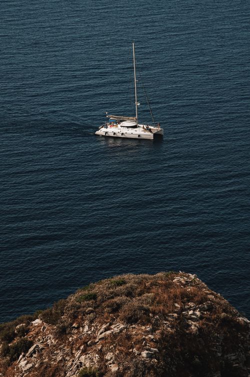 Free A serene yacht sailing near the rocky coastline of Bonifacio, Corsica, captured from a high vantage point. Stock Photo