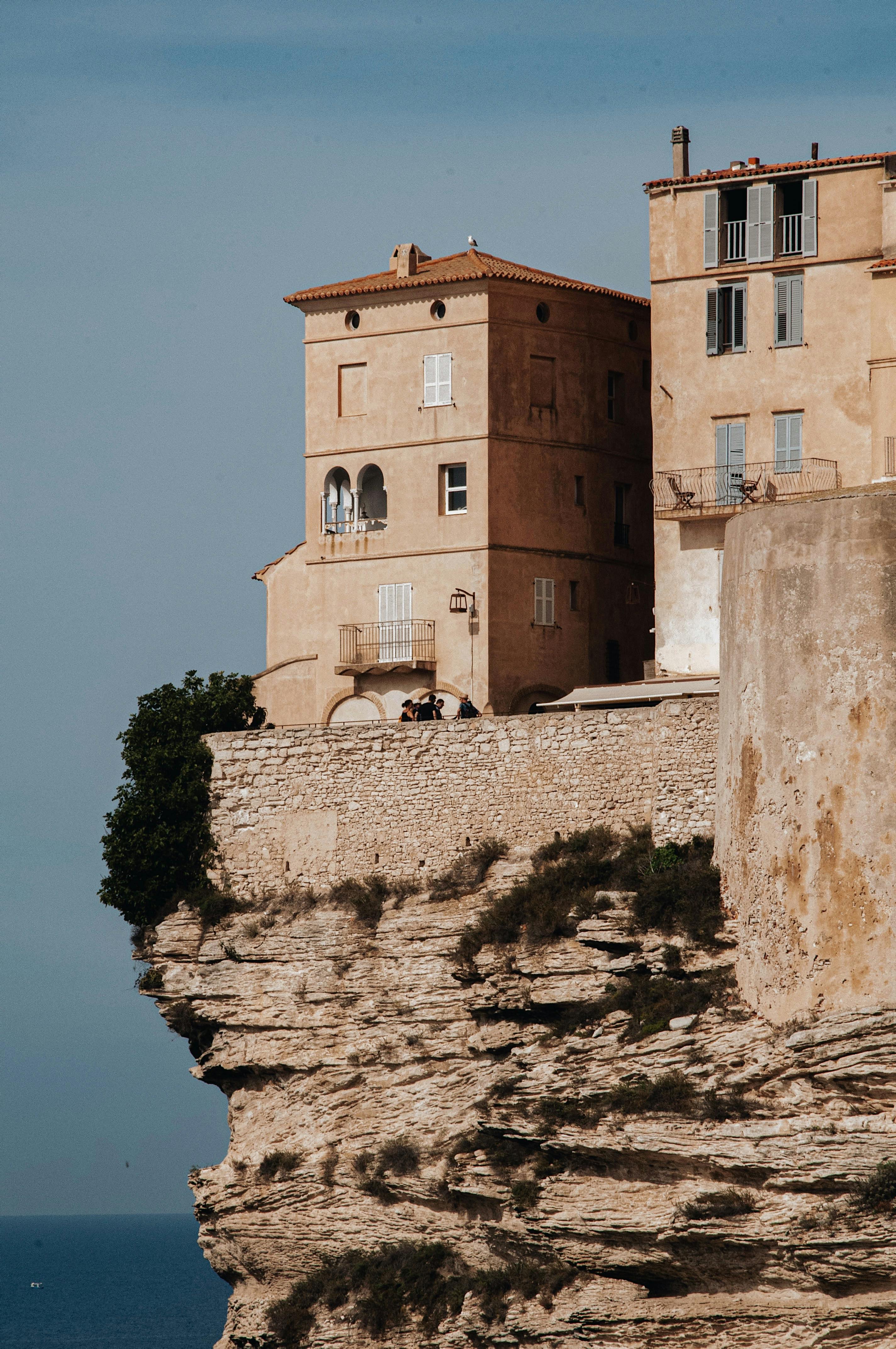 Historic fortress on cliffs in Bonifacio, Corsica with sea view under summer sun.