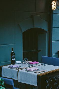 Elegant dining table set for two with wine bottle and glasses, offering a romantic ambiance.
