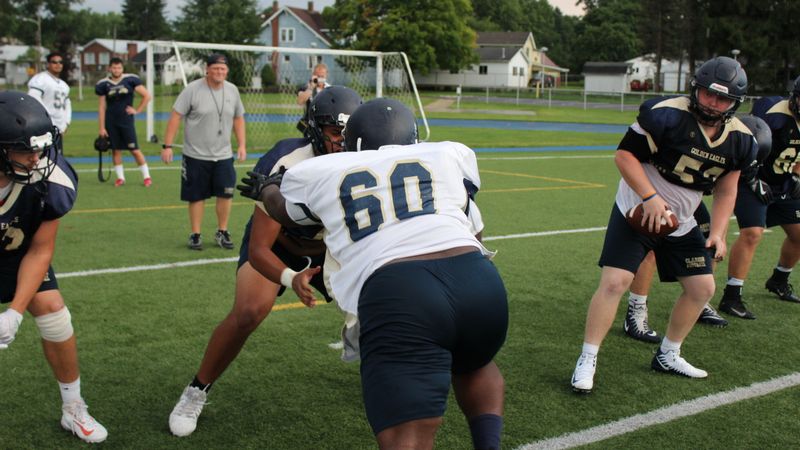 Dynamic scene of American football players in action during practice. Focus on teamwork and strategy.